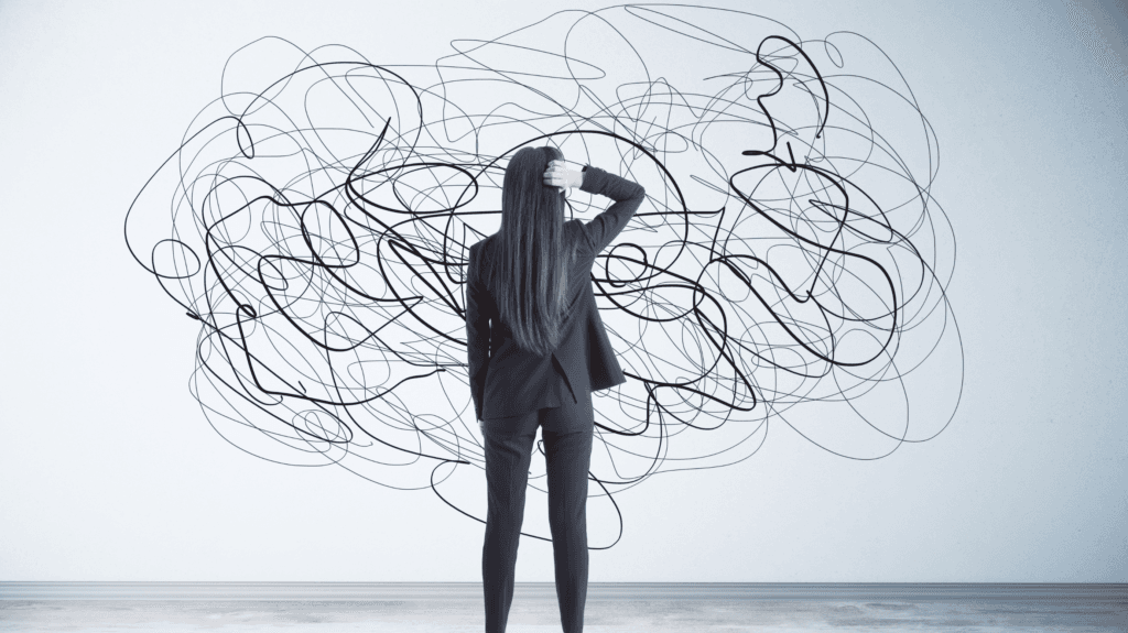 uma mulher, olhando para uma parede rabiscada. aparentemente confusa com o desenho