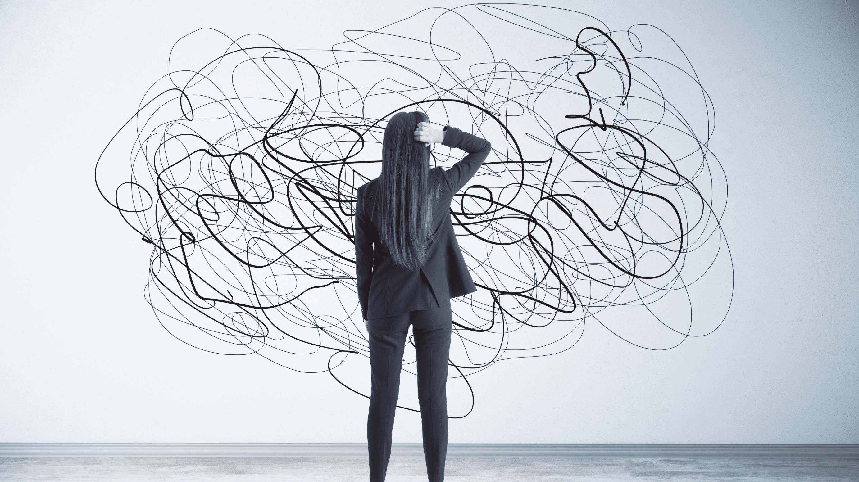 uma mulher, olhando para uma parede rabiscada. aparentemente confusa com o desenho